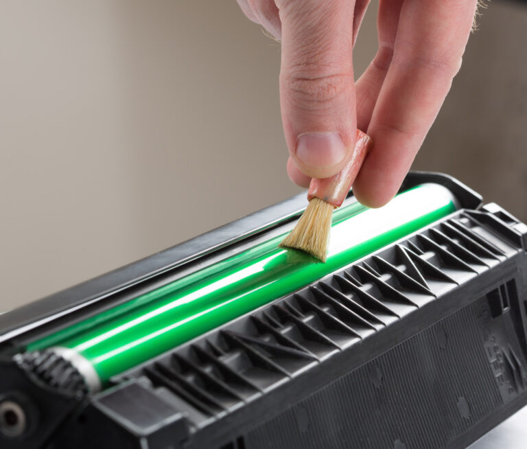 Technician hand cleaning printer toner cartridge