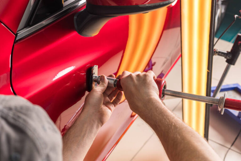 technician removes dents on the car using the method without painting